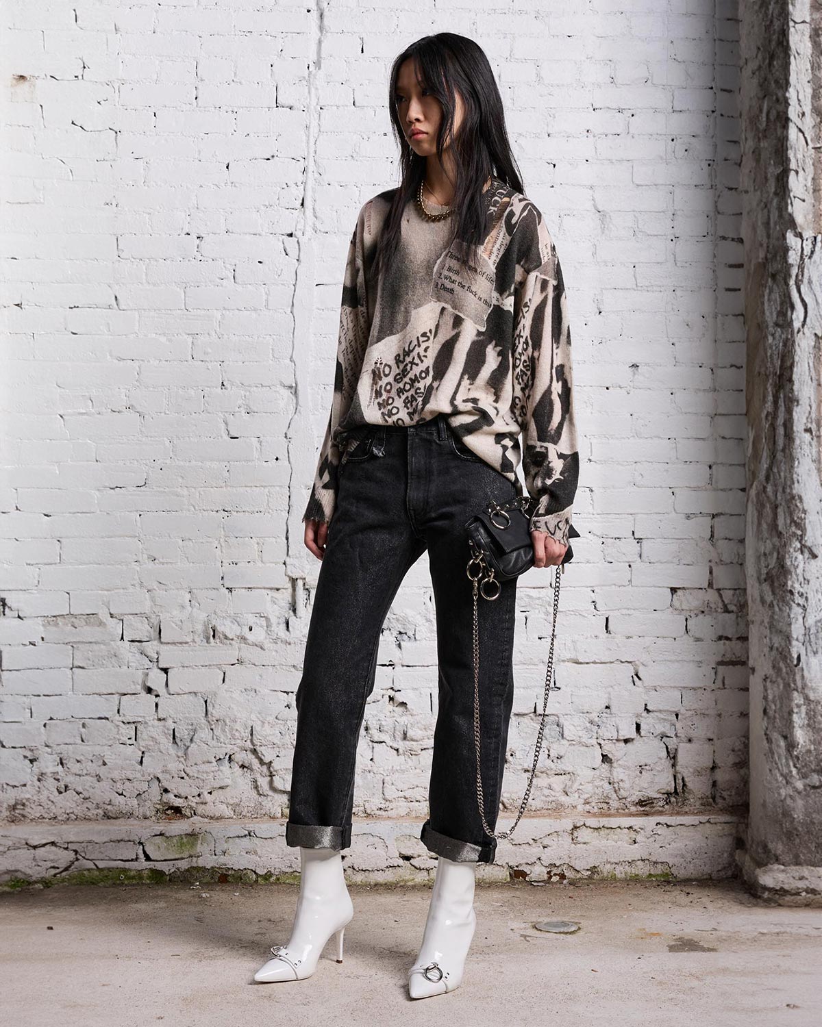 Pull oversize en cachemire imprimé journal noir et blanc R13. Porté avec un jeans noir. 
