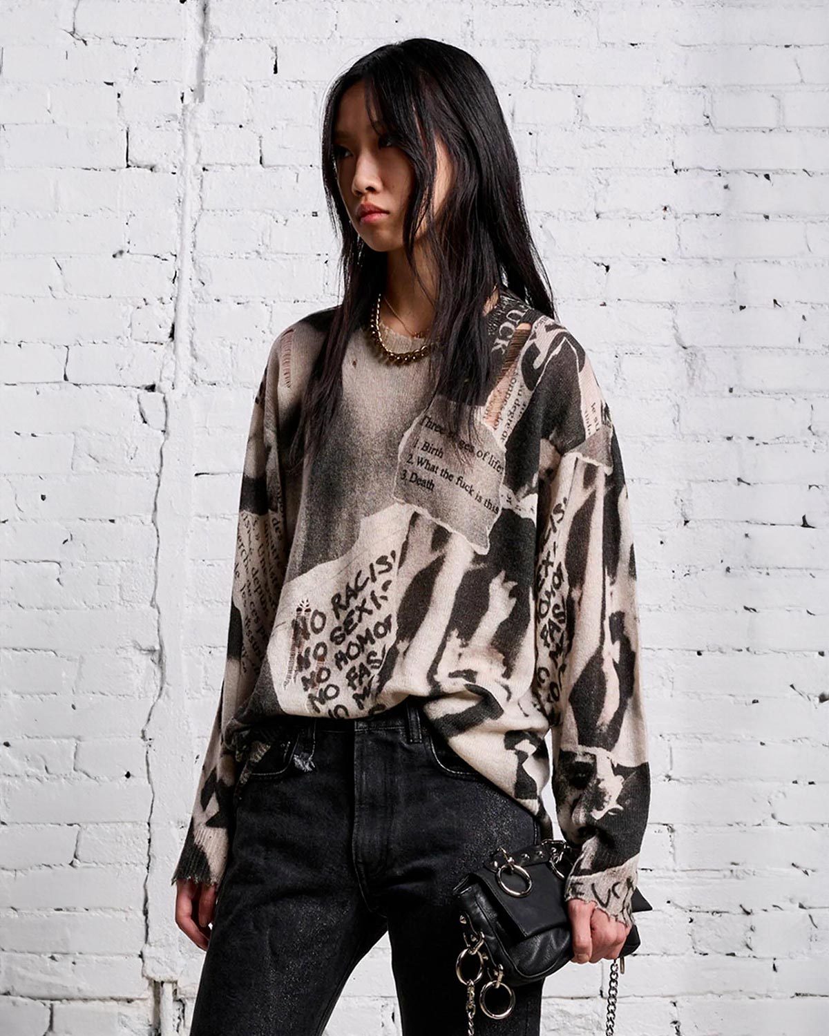 Pull oversize en cachemire imprimé journal noir et blanc R13. Porté de face légèrement rentré sur le devant.