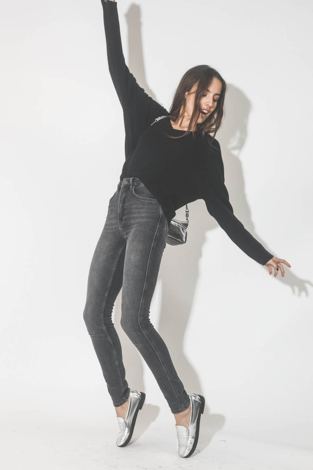 Pull col V en cachemire noir Lee Anine Bing. Port&eacute; avec le devant du pull rentr&eacute; dans le jean taille haute.