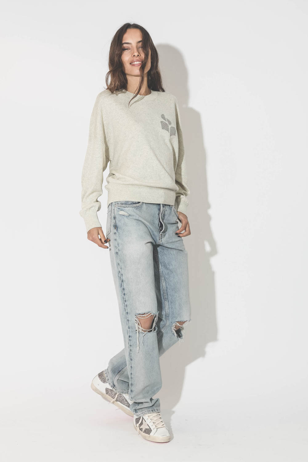 Pull col rond en coton gris clair logo argent Marisans Isabel Marant Etoile. Porté avec un jeans bleu ciel déchiré aux genoux.