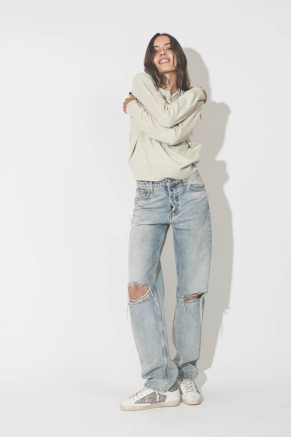 Pull col rond en coton gris clair logo argent Marisans Isabel Marant Etoile. Porté avec un jeans droit bleu ciel déchiré aux genoux et des baskets à paillettes.