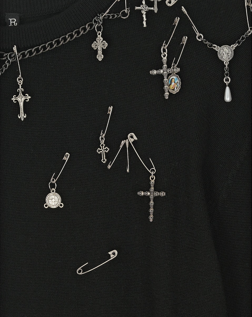 Pull Tight Waist Crewneck Sweater R13 en laine noire, orné de bijoux argentés. Détails des bijoux croix, épingles à nourrice, médailles.
