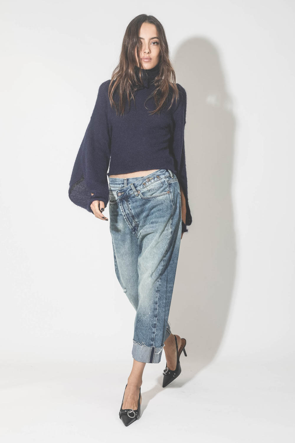 Pull dos nu col roulé en mohair bleu Maison Flaneur. Porté avec un jeans et des escarpins.