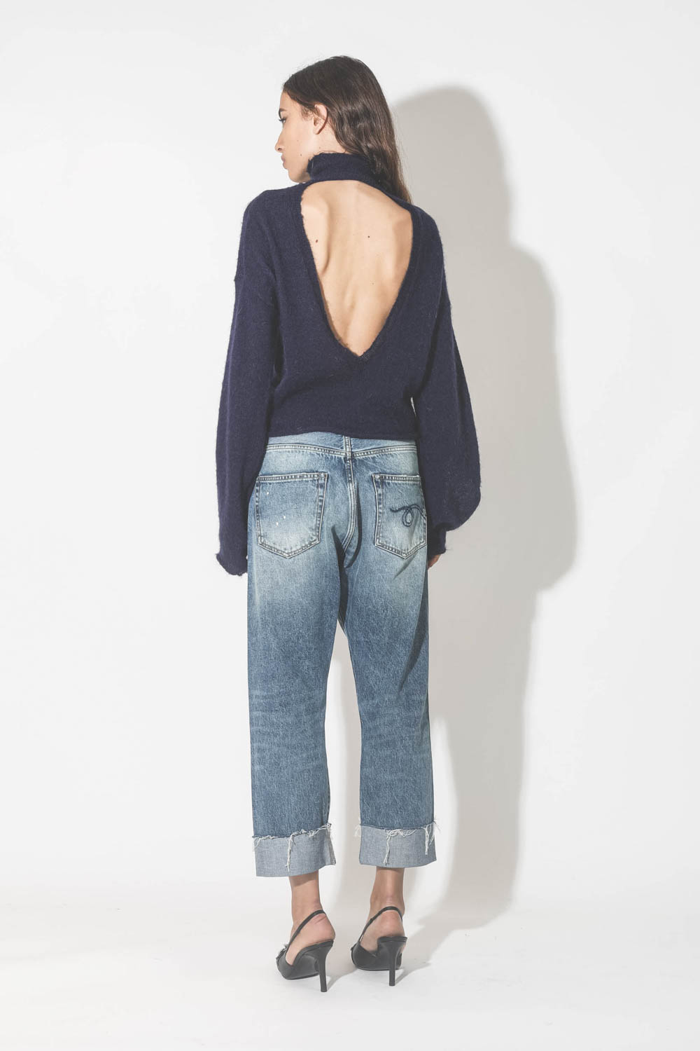 Pull dos nu col roulé en mohair bleu Maison Flaneur. Porté de dos avec un jeans bleu ciel.