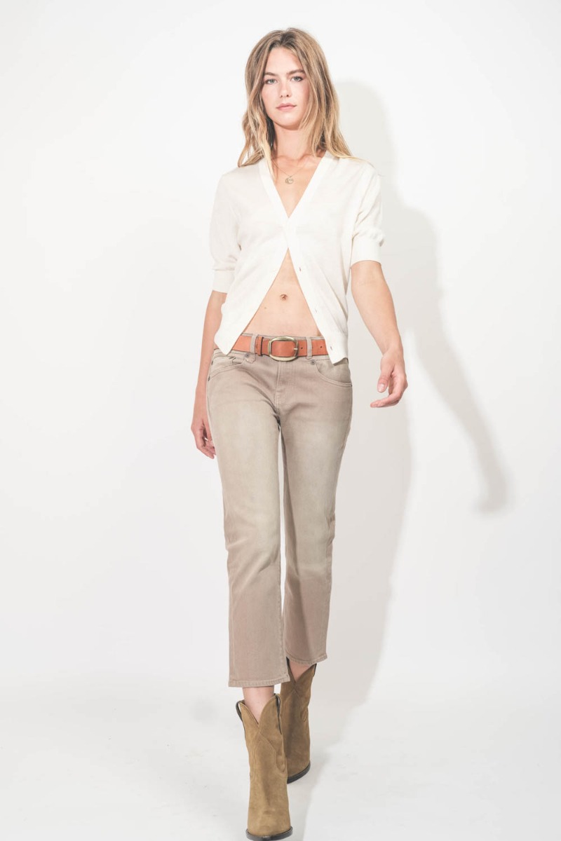 Cardigan Elbow Sleeve R13 en laine mérinos crème. Porté avec un jean taille basse beige.