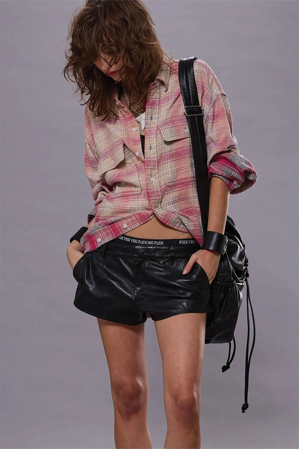 Produit Chemise oversize manches longues en coton à carreaux rose et gris blanchis Relaxed Workshirt R13. Porté avec un mini-short en cuir noir.