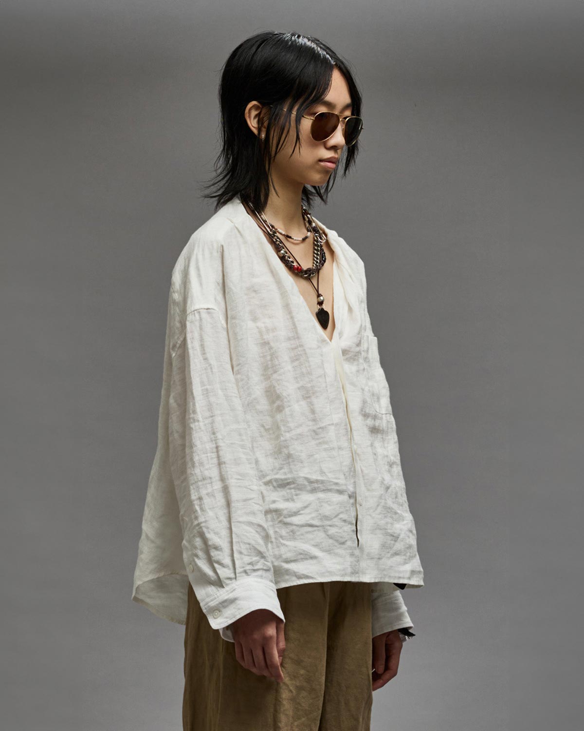 Chemise  froissée manches longues sans col en lin et viscose blanche Twisted Neck Shirt R13. Porté de profil.