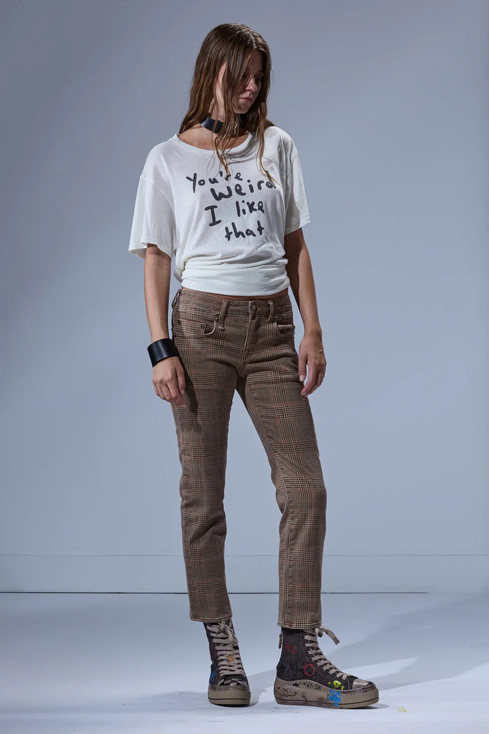 Jean slim taille basse Boy Straight R13 en coton à carreaux marron, porté de face avec des sneakers compensées.