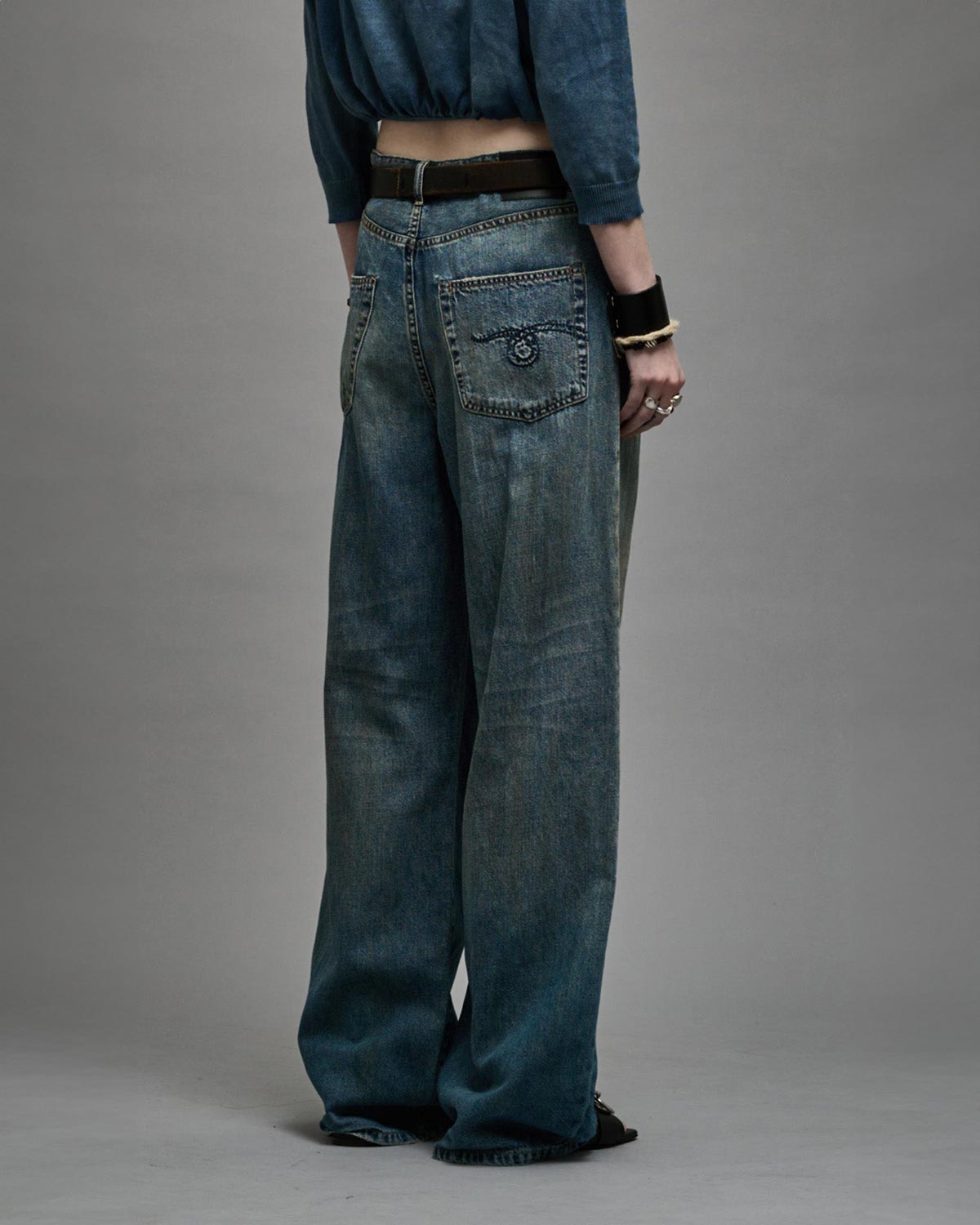 Jean large à pinces en Denim souple bleu Damon Pleated Wide Leg R13. Porté de profil dos.