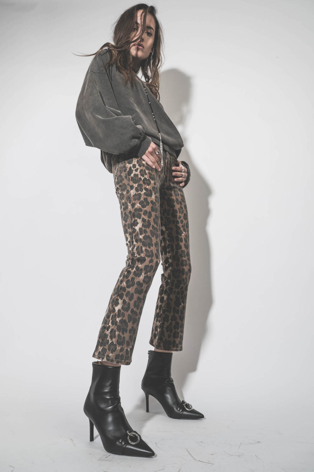 Produit Jean Skinny taille basse court et légèrement évasé en jean léopard délavé Kick Fit R13. Porté avec des boots à talons en cuir noir. 