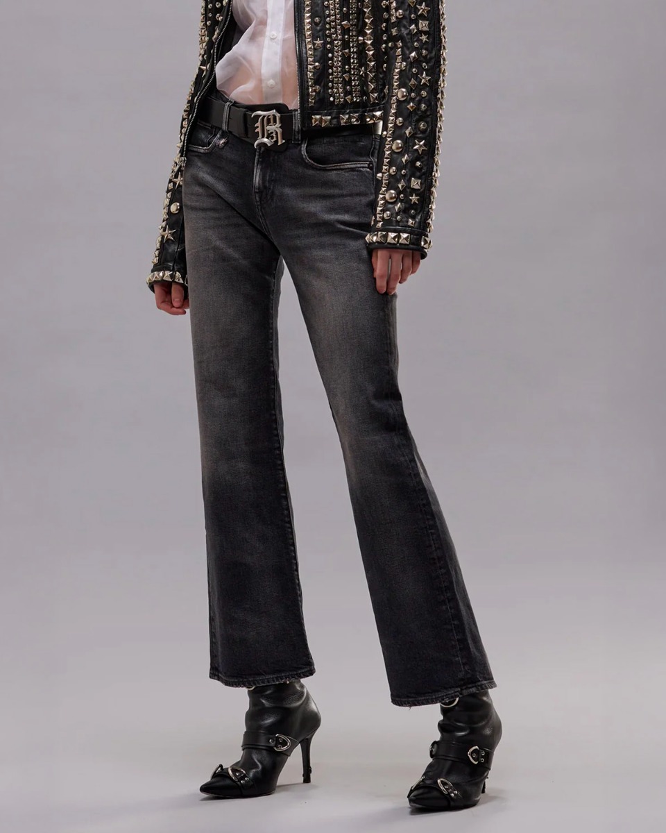 Jean court &eacute;vas&eacute; Joan Cropped Flare R13 en denim noir noir d&eacute;lav&eacute; Essex Black Stretch, port&eacute; avec des boots &agrave; talons R13.