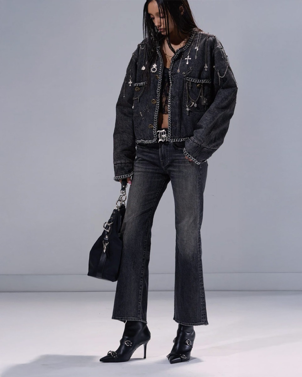 Produit Jean évasé Joan Kick Flare R13 en denim noir délavé Kennet Black Stretch, porté avec des boots à talons en cuir noir. 