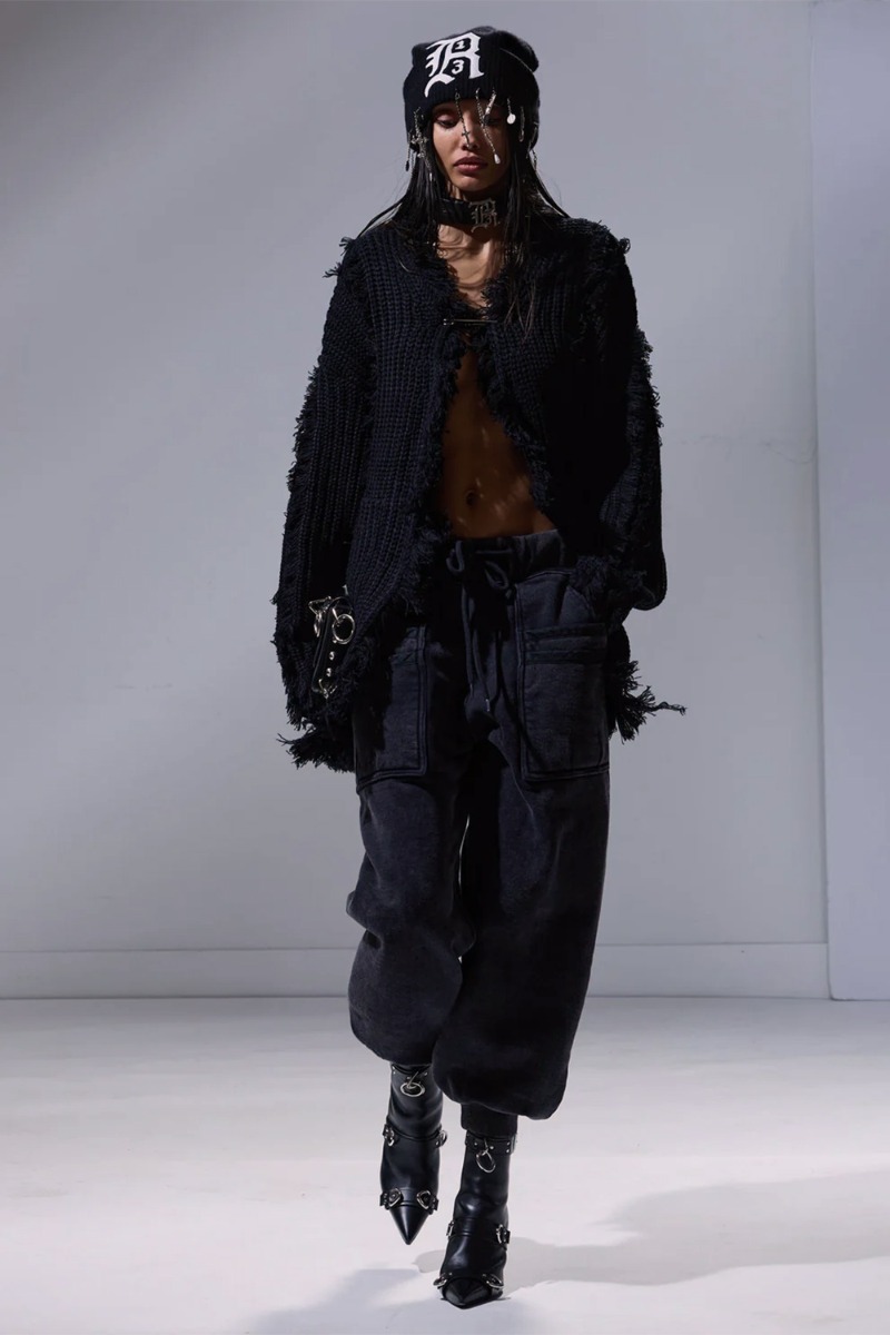 Produit Pantalon de jogging Layered Pocket Sweatpant R13 en coton noir délavé, porté avec des boots à talons en cuir noir.