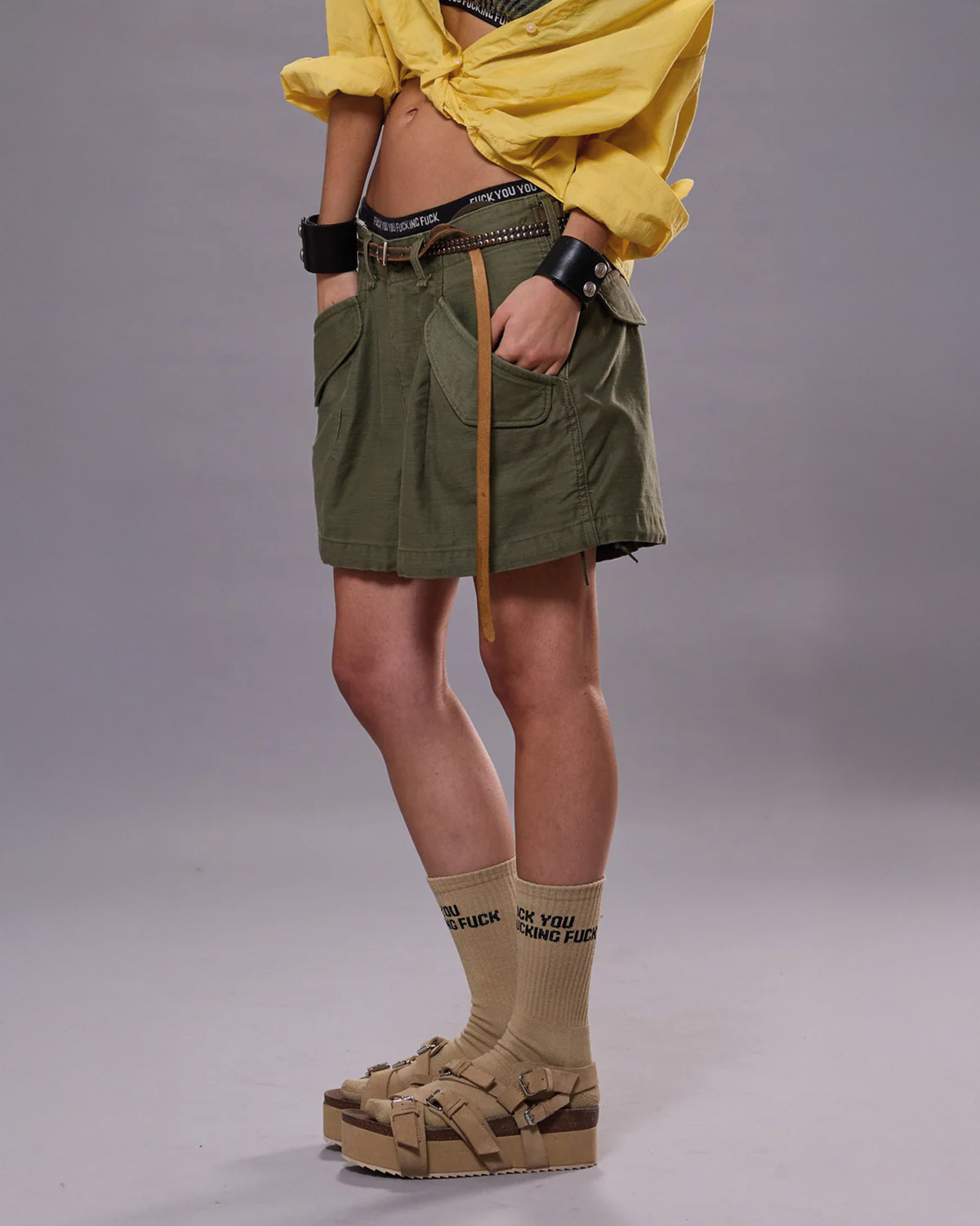 Short court en toile kaki esprit army Cargo Marianne R13. Porté avec des sandales compensées.