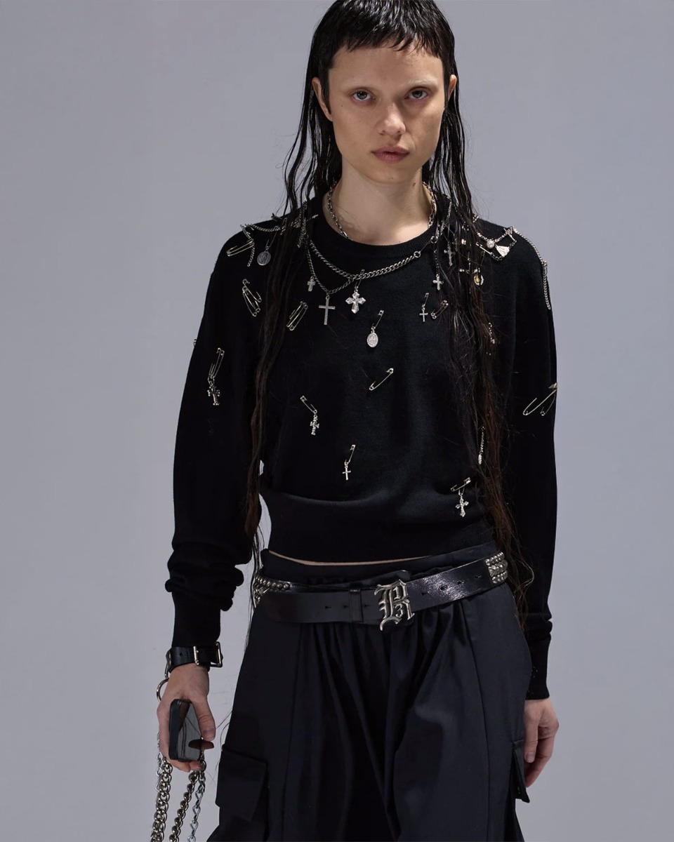 Pull Tight Waist Crewneck Sweater R13 en laine noire, orné de bijoux argentés, porté de face.