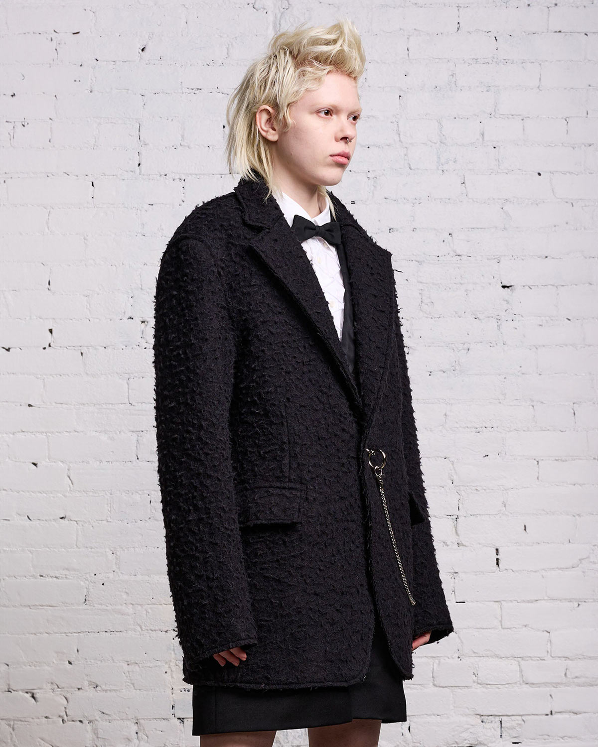 Veste oversize en laine grattée noire fermeture anneau et chaine en métal argent R13. Porté avec une chemise blanche.