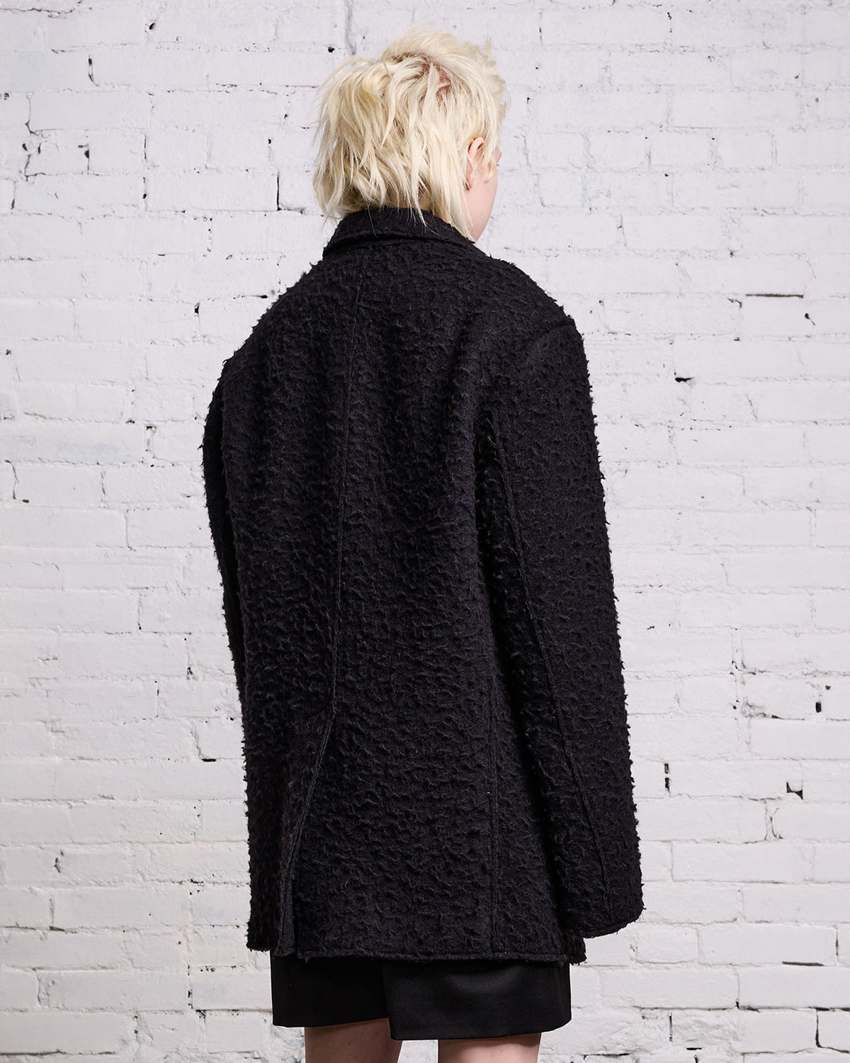 Veste oversize en laine grattée noire fermeture anneau et chaine en métal argent R13. Porté de profil dos.