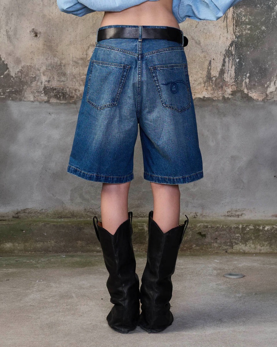 Short bermuda Relaxed R13 en denim bleu d&eacute;lav&eacute; &laquo; Depot Blue &raquo;, port&eacute; de dos avec une ceinture.