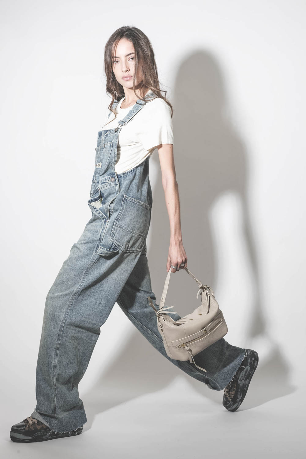 Sneakers compensées en toile léopard Kurt R13. Porté de profil avec une salopette en jean.