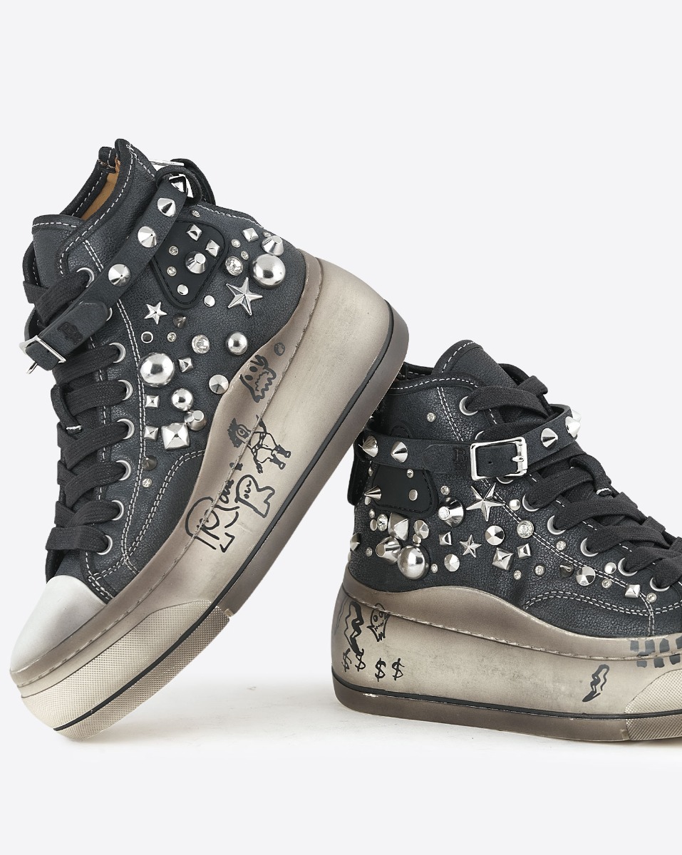 Baskets compens&eacute;es Kurt R13 en toile noire clout&eacute;e en m&eacute;tal argent&eacute; et bracelet de cheville en cuir noir. Semelle &eacute;cru avec graffitis. D&eacute;tails des graffitis noirs sur les semelles.