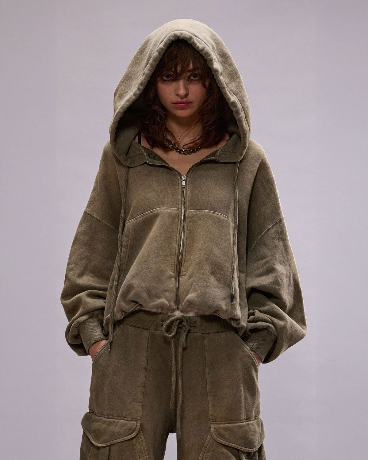 Sweatshirt avec zip et capuche forme ballon poche Kangourou vert olive R13. Porté de face capuche sur la tête.