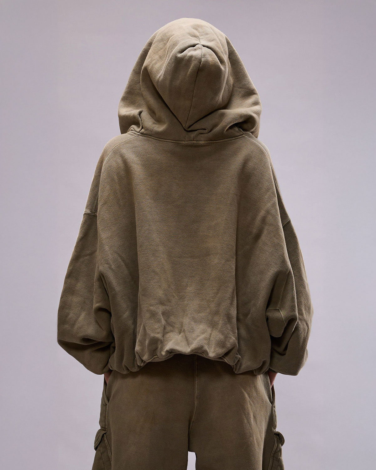Sweatshirt avec zip et capuche forme ballon poche Kangourou vert olive R13. porté de dos capuche sur la tête.