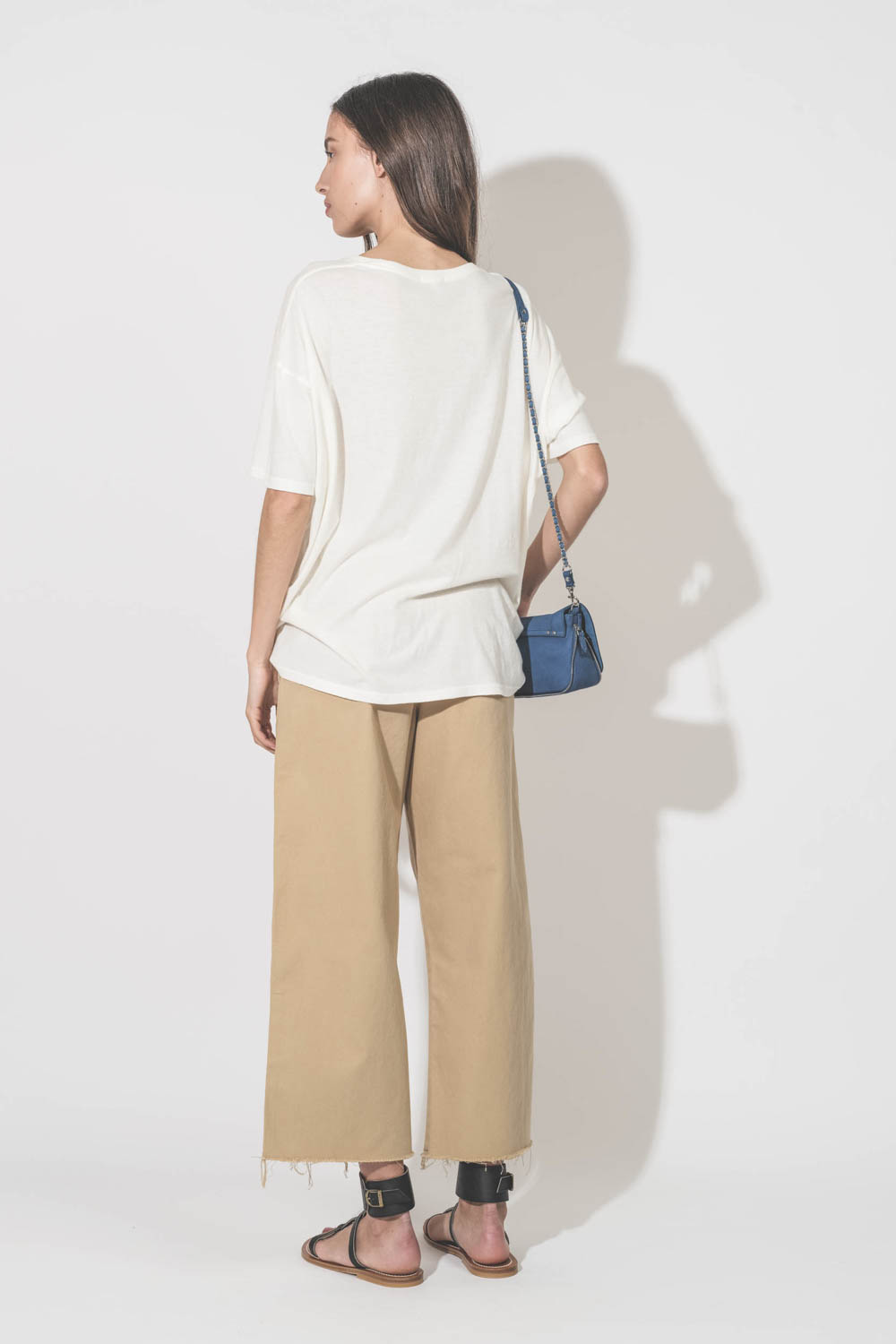 Tee-shirt manches courtes en coton et cachemire écru imprimé devant Smiley doigts d'honneur "Have A Nice Day. Thank You !" R13. Porté de dos avec un pantalon large chino beige Denimist et des sandales plates en cuir noir Caravelle K.Jacques St-Tropez. Min