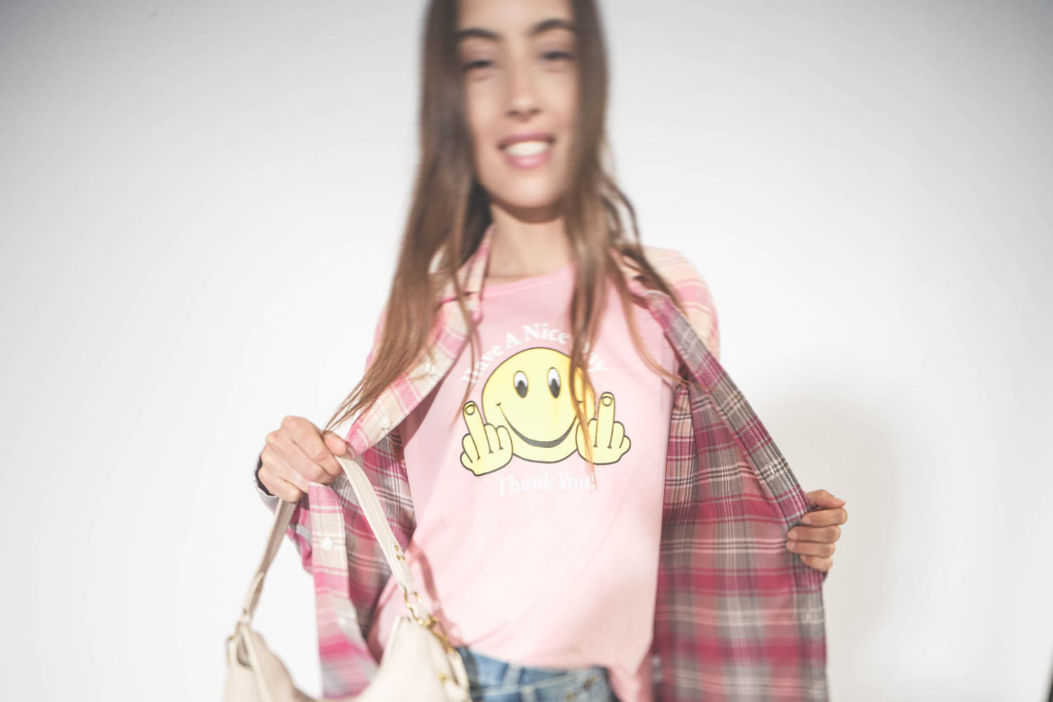 Tee-shirt manches courtes Smiley Have A Nice Day R13 en coton et cachemire rose. Porté sous une chemise à carreaux roses.