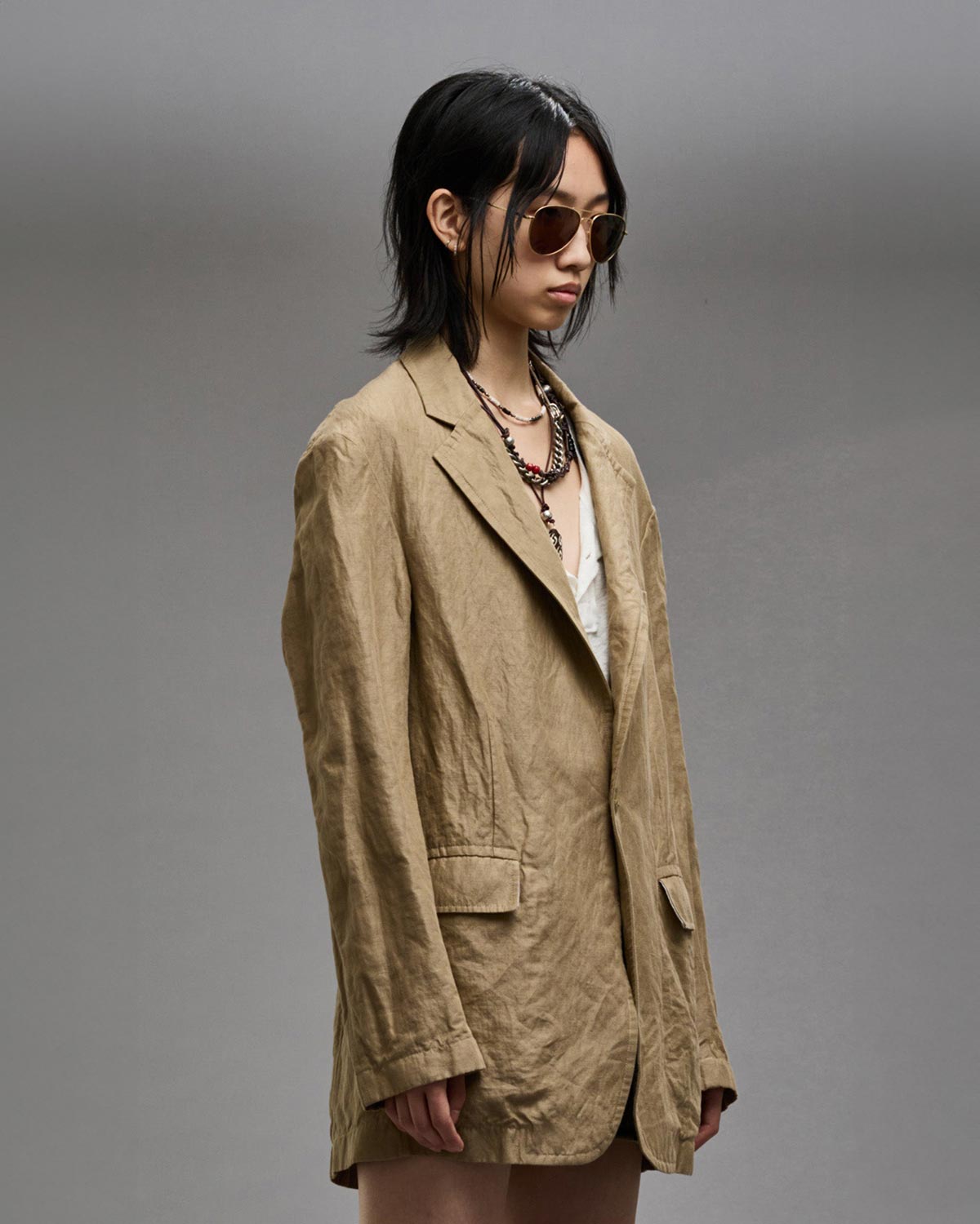 Veste over size froissé en coton beige Ragged Blazer R13. Porté fermée de profil.