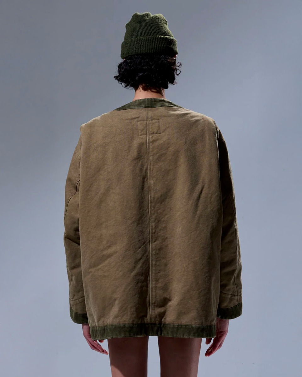 Veste oversize matelassée Cord Trimmed Chore Jacket R13 en toile de coton marron bordée de velours côtelé kaki. Portée de profil de dos.