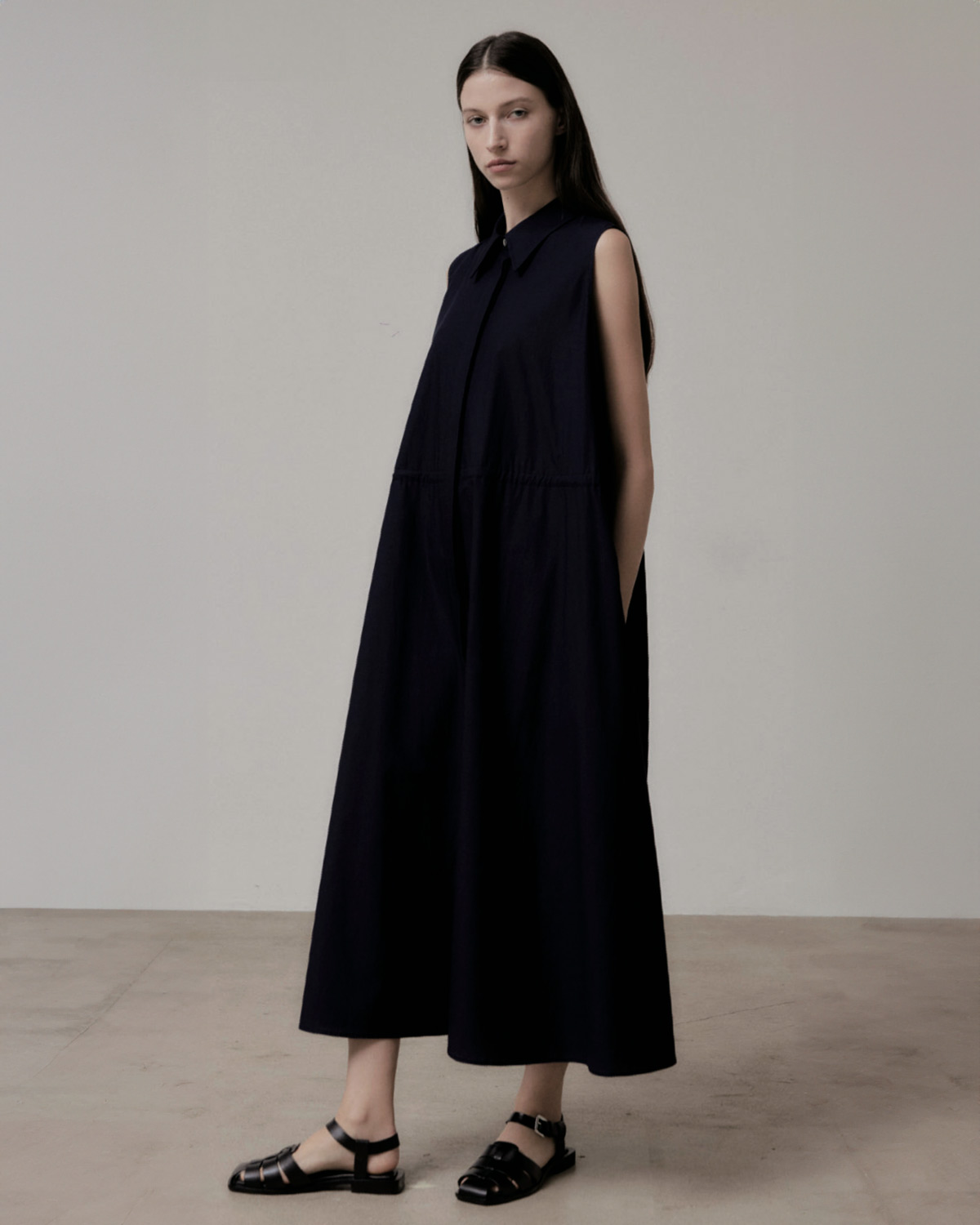 Robe longue sans manche en popeline de coton noire Vis à Vis. Porté de face.
