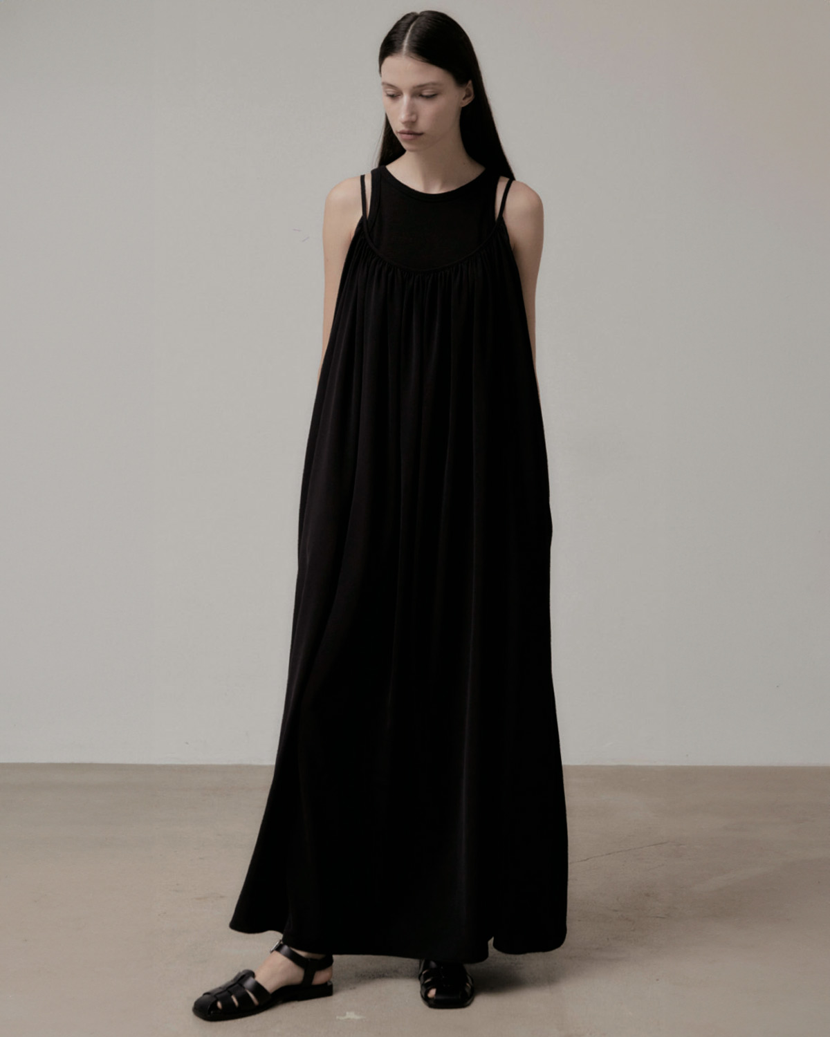 Produit Robe longue noire fines bretelles Vis à Vis. Porté sur un débardeur.