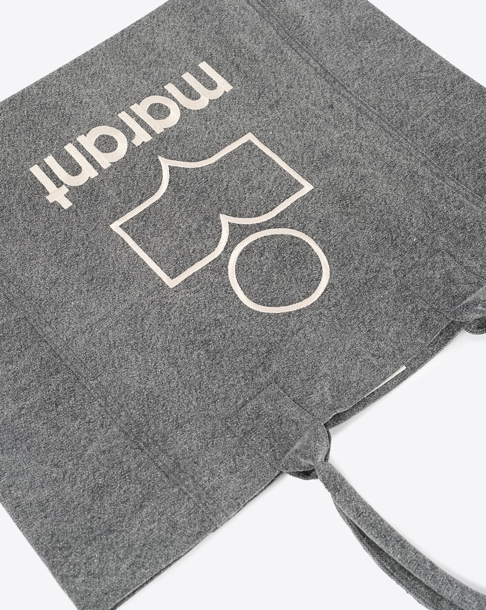 Produit Cabas Yenky Isabel Marant en toile délavée anthracite logo "MARANT" brodé blanc. Porté main ou épaule. Détail de la toile et du logo brodé.
