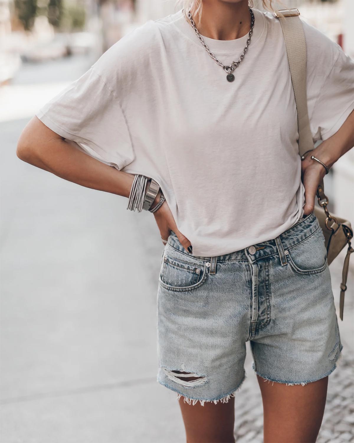 Short en jean bleu ciel usé Mikuta. Porté avec un tee-shirt écru Mikuta et des bijoux en argent Mikuta. 