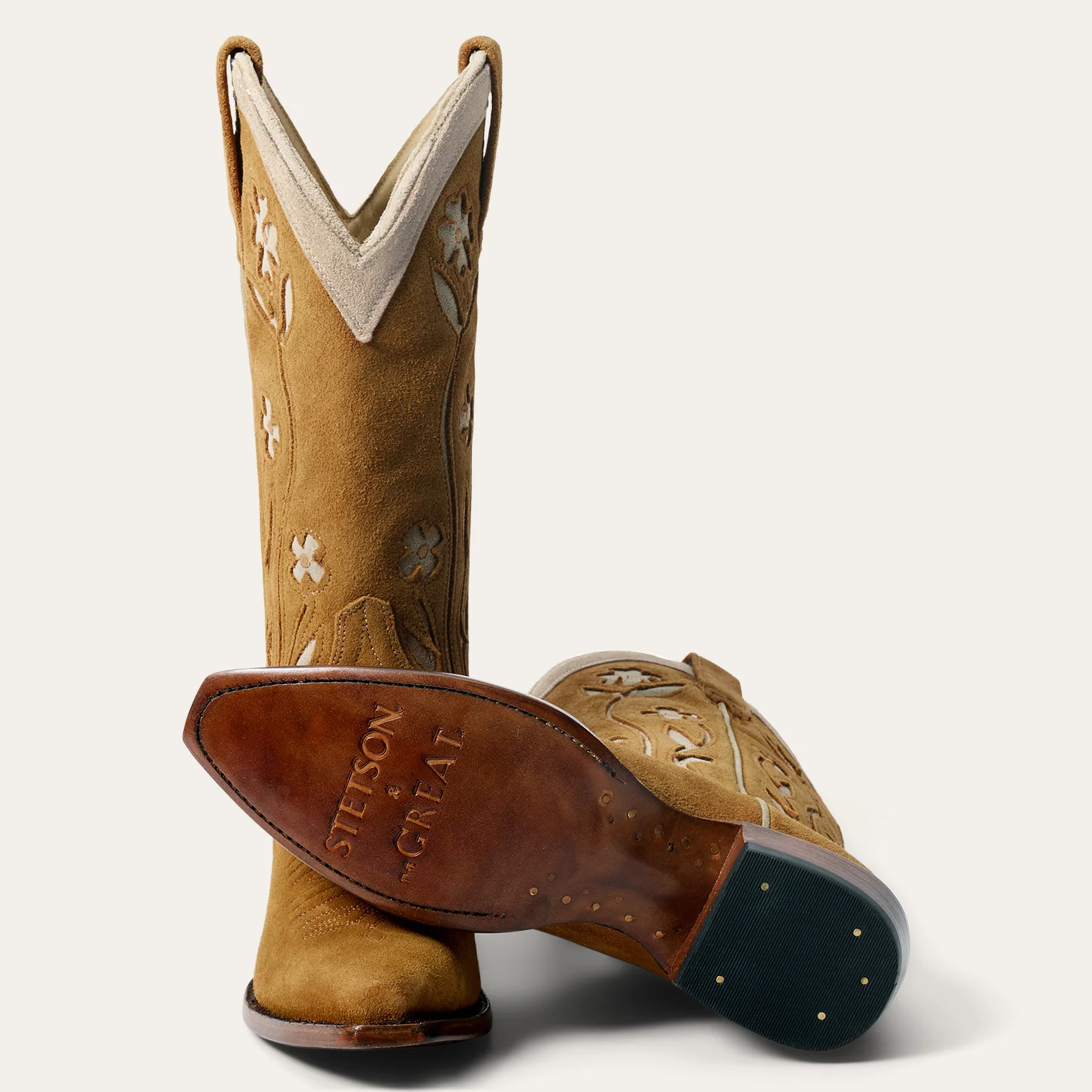 Bottes de cowboy Stetson x The Great en daim camel fleurs brod&eacute;es &eacute;cru, vues de face et d&eacute;tail du dessous de la semelle. Edition limit&eacute;e.