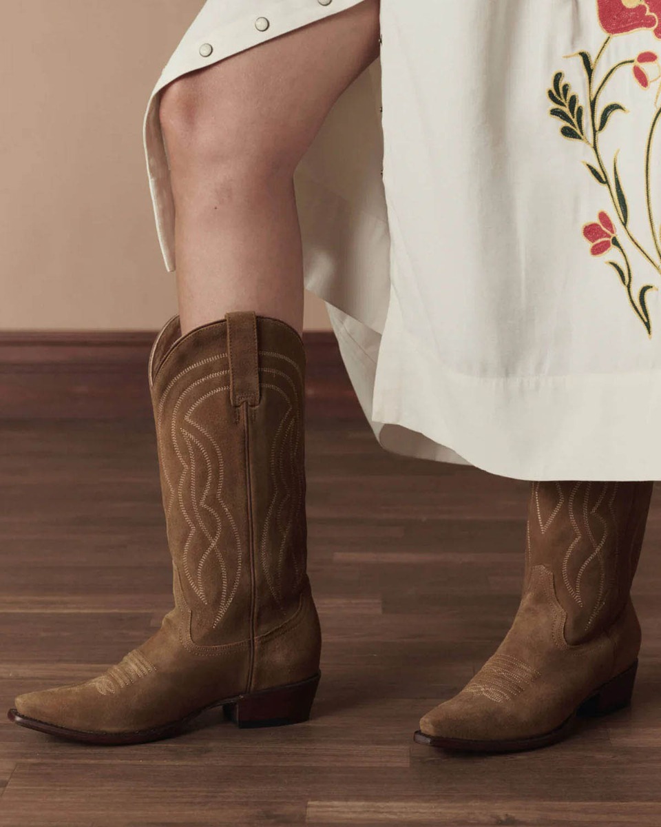 Bottes de cowboy Stetson & The Great en daim camel, port&eacute;es de profil avec une jupe longue The Great. Edition limit&eacute;e.