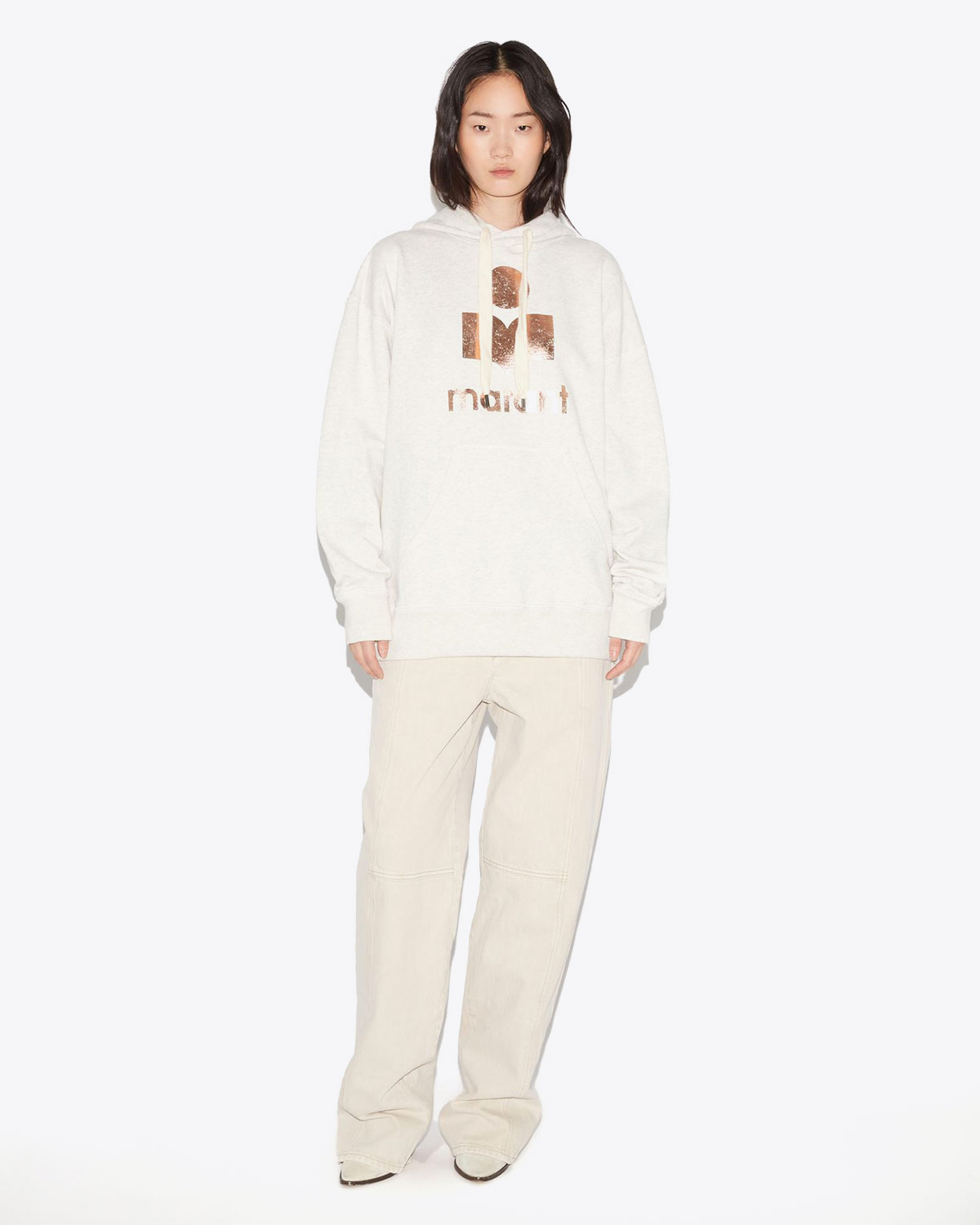 Sweat-shirt à capuche oversize écru logo métallisé rose doré Mansel Isabel Marant Etoile. Porté avec un pantalon écru.