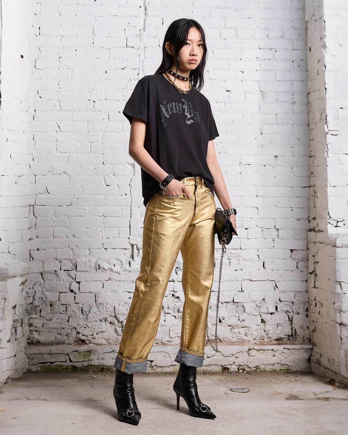 Tee-shirt manches courtes en coton noir sérigraphie New-York R13. Porté avec un pantalon lamé doré.