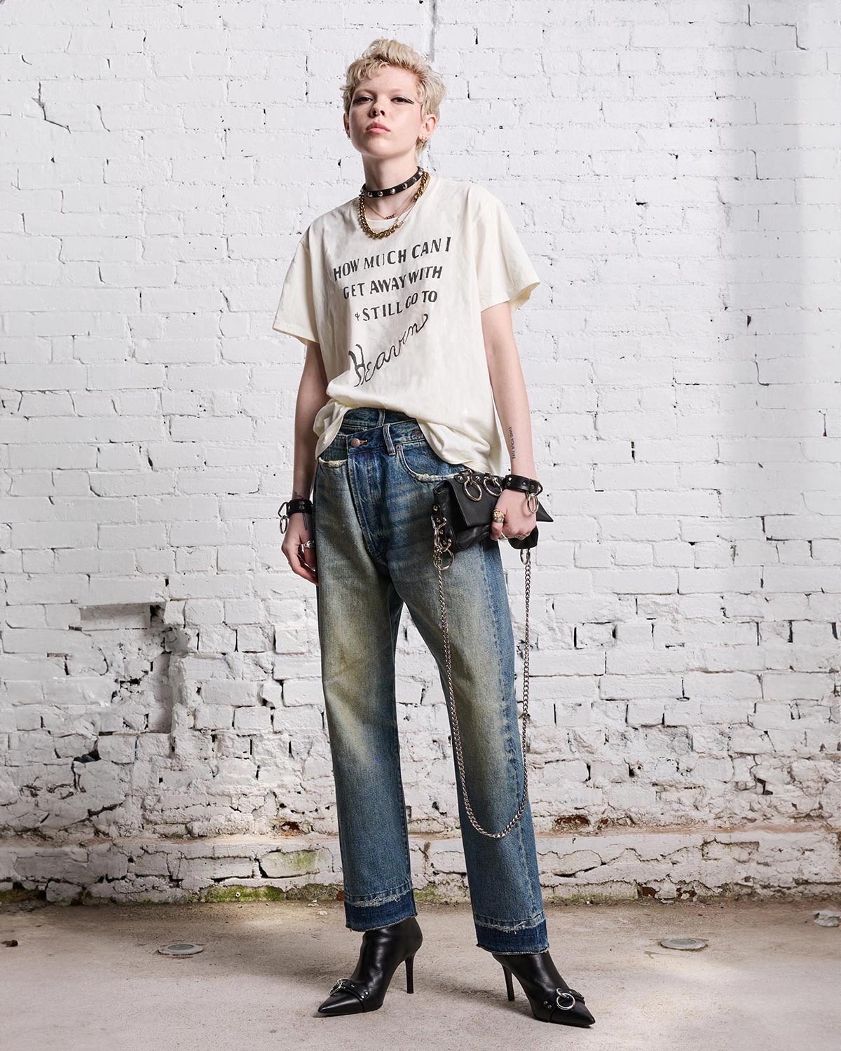 Tee-shirt manches courtes en coton &eacute;cru imprim&eacute; en lettres noires "How much can I get away with still go to heavens" R13. Port&eacute; avec un jeans Crossover bleu.