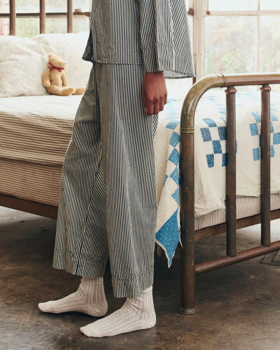 Pantalon Easy Sleep The Great en coton ray&eacute; noir et cr&egrave;me, port&eacute; de profil.