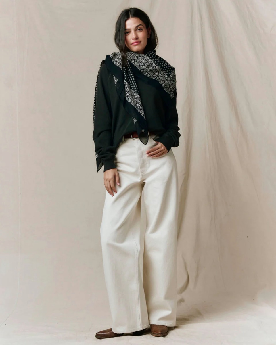 Grand foulard Bandana The Great en coton noir d&eacute;lav&eacute;, nou&eacute; sur le c&ocirc;t&eacute; autour du cou.