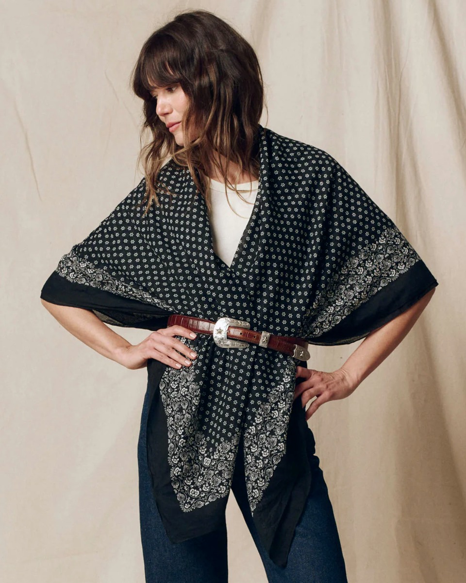 Grand foulard Bandana The Great en coton noir d&eacute;lav&eacute;, port&eacute; sur les &eacute;paules en triangle et ceintur&eacute; &agrave; la taille.