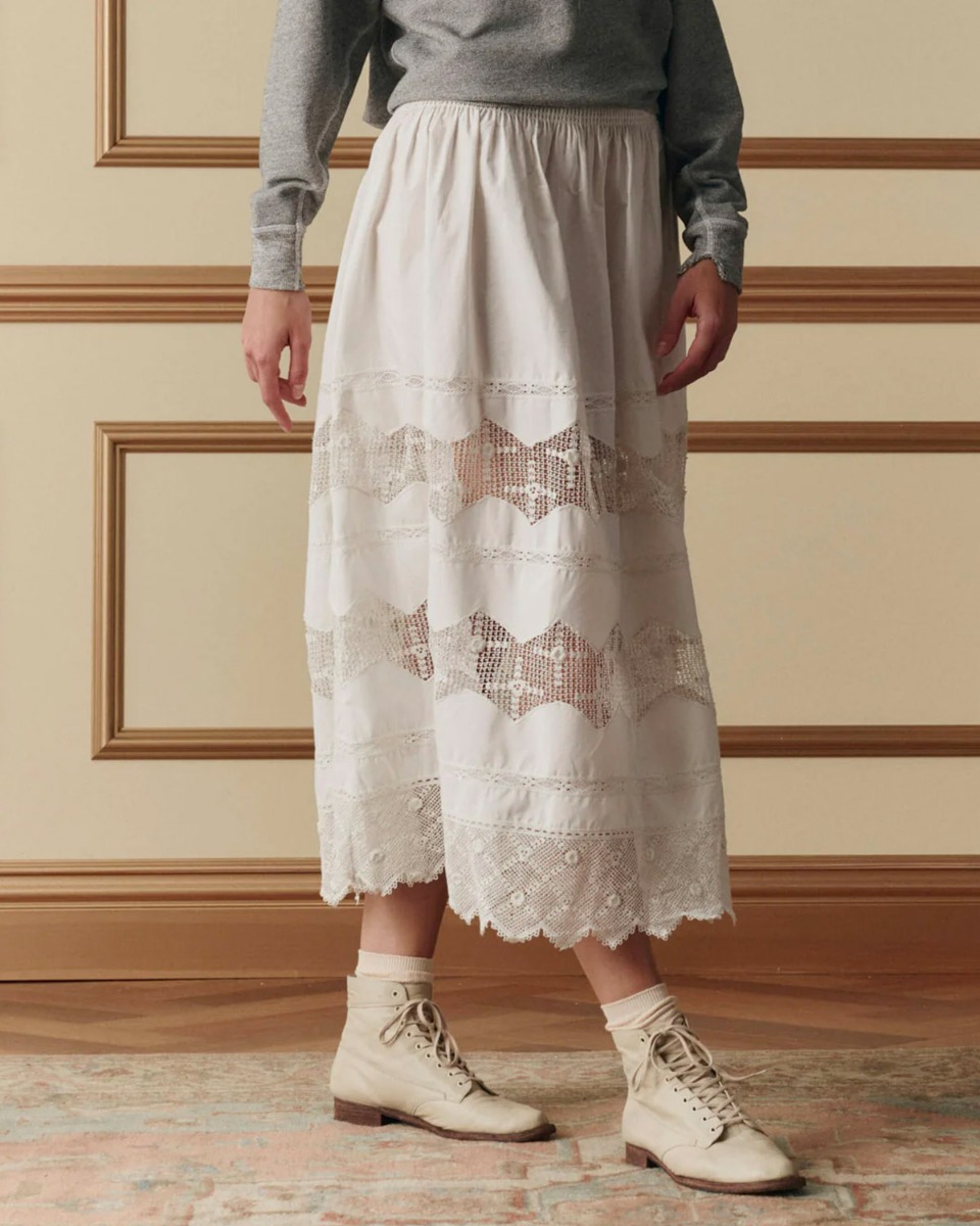 Jupe longue Rosette Crochet The Great en coton et dentelle blanche, port&eacute;e de profil.
