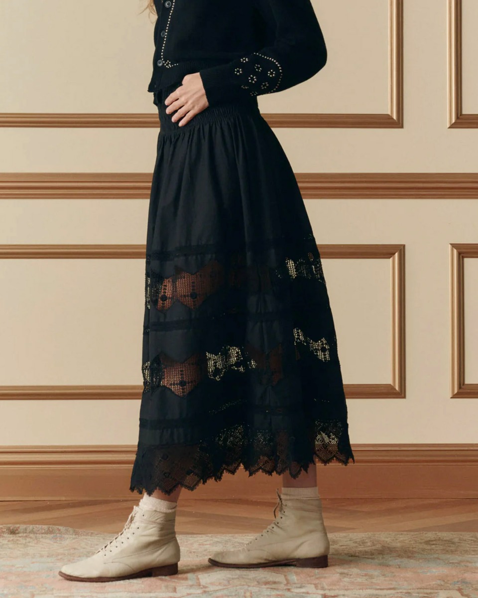 Jupe longue Rosette Crochet The Great en coton et dentelle noire, port&eacute;e de profil.