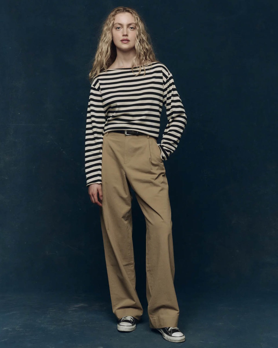 Marini&egrave;re Sailor The Great en coton ray&eacute; noir et cr&egrave;me, port&eacute;e de face avec un pantalon en toile beige.