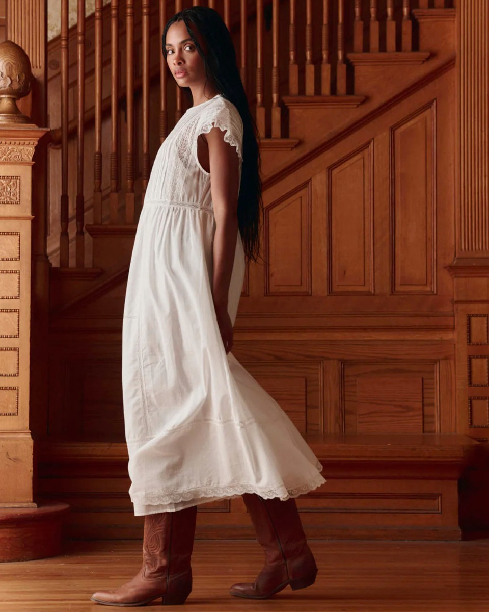 Robe longue Sonnet The Great en coton blanc et dentelle, port&eacute;e de profil.