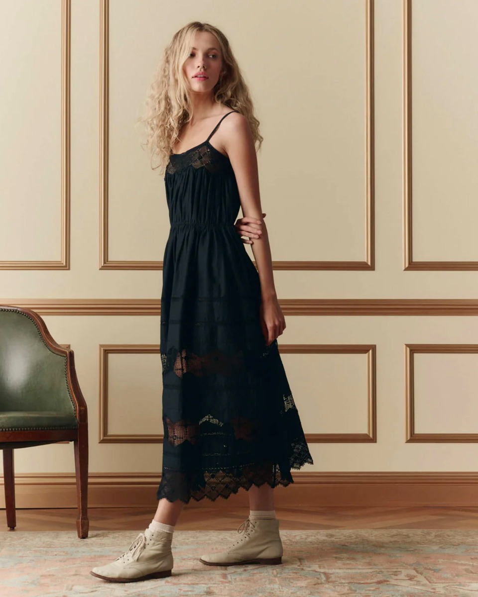 Robe bustier &agrave; bretelles Rosette The Great en coton et dentelle noire, port&eacute;e de profil.