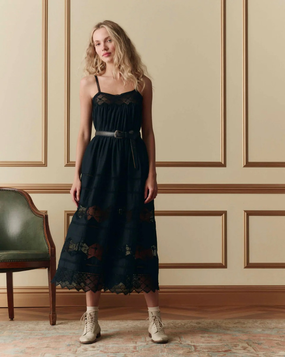 Robe bustier &agrave; bretelles Rosette The Great en coton et dentelle noire, port&eacute;e de face avec une ceinture.