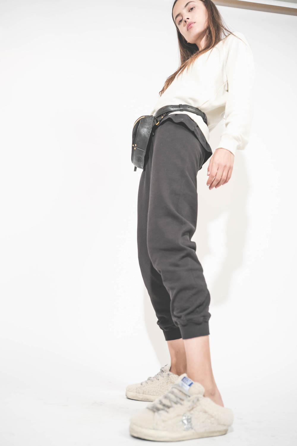 Sweat-shirt manches longues col rond en bouclette de coton écru Shrunken The Great. Porté avec un bas de jogging en bouclette de coton noir Cropped The Great et des sneakers Super Star sabot en fourrure écru Shearling 10757 Golden Goose. Sac banane en cui