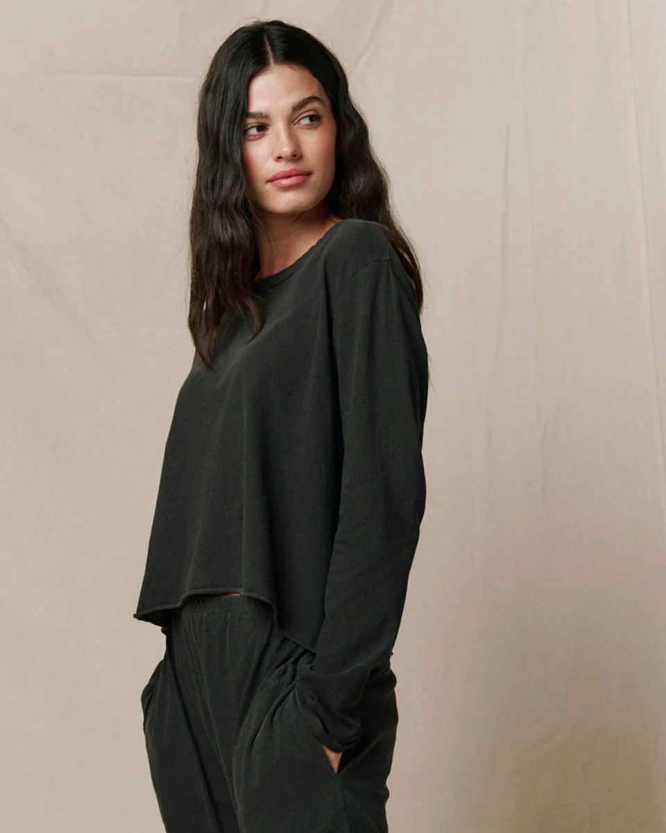 Tee-shirt Long Sleeve Crop Tee The Great en coton noir d&eacute;lav&eacute; &laquo; washed black &raquo;, port&eacute; de profil.